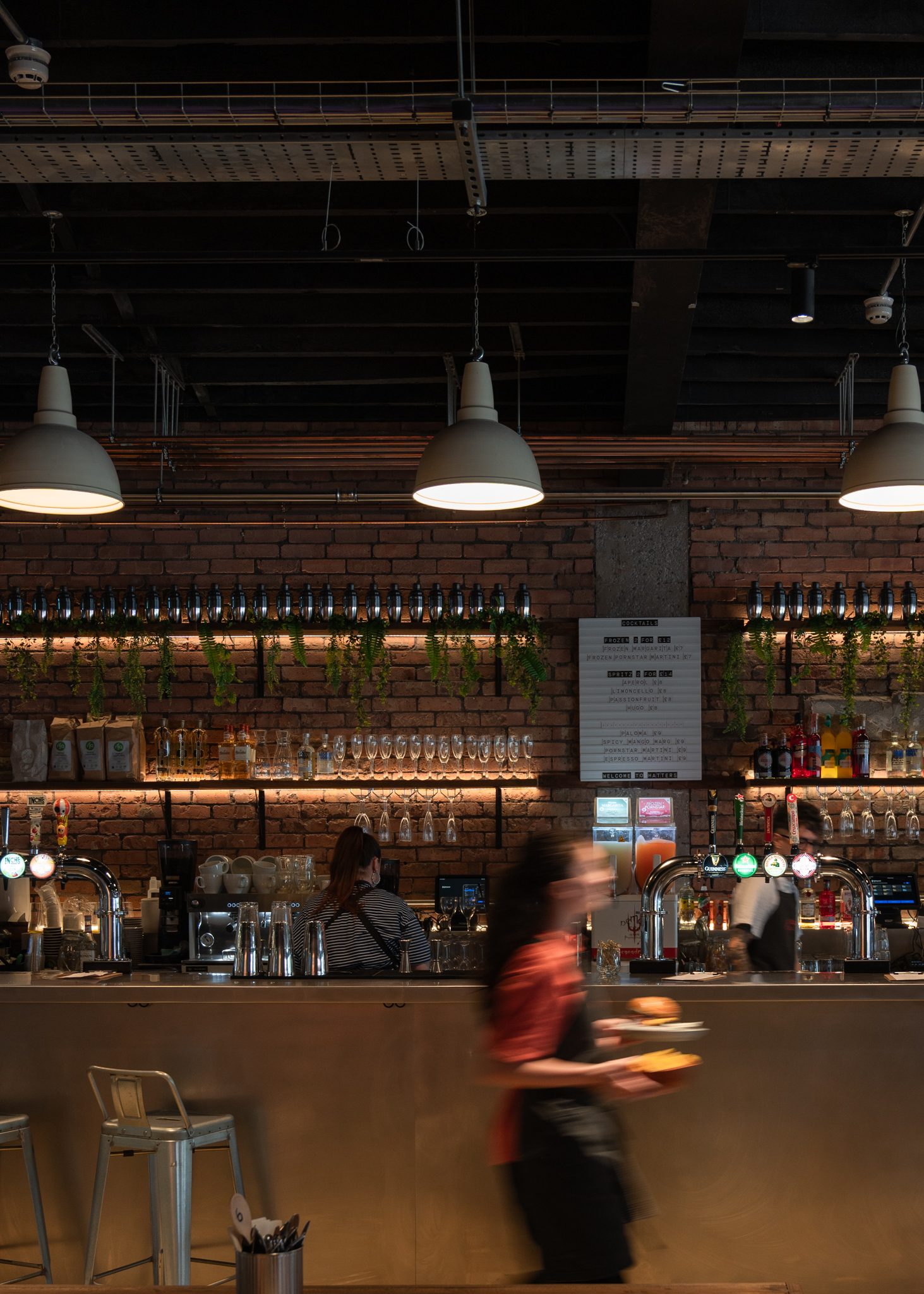 Inside Hatters Food and Drinks Hall — brick bar and pendant lighting