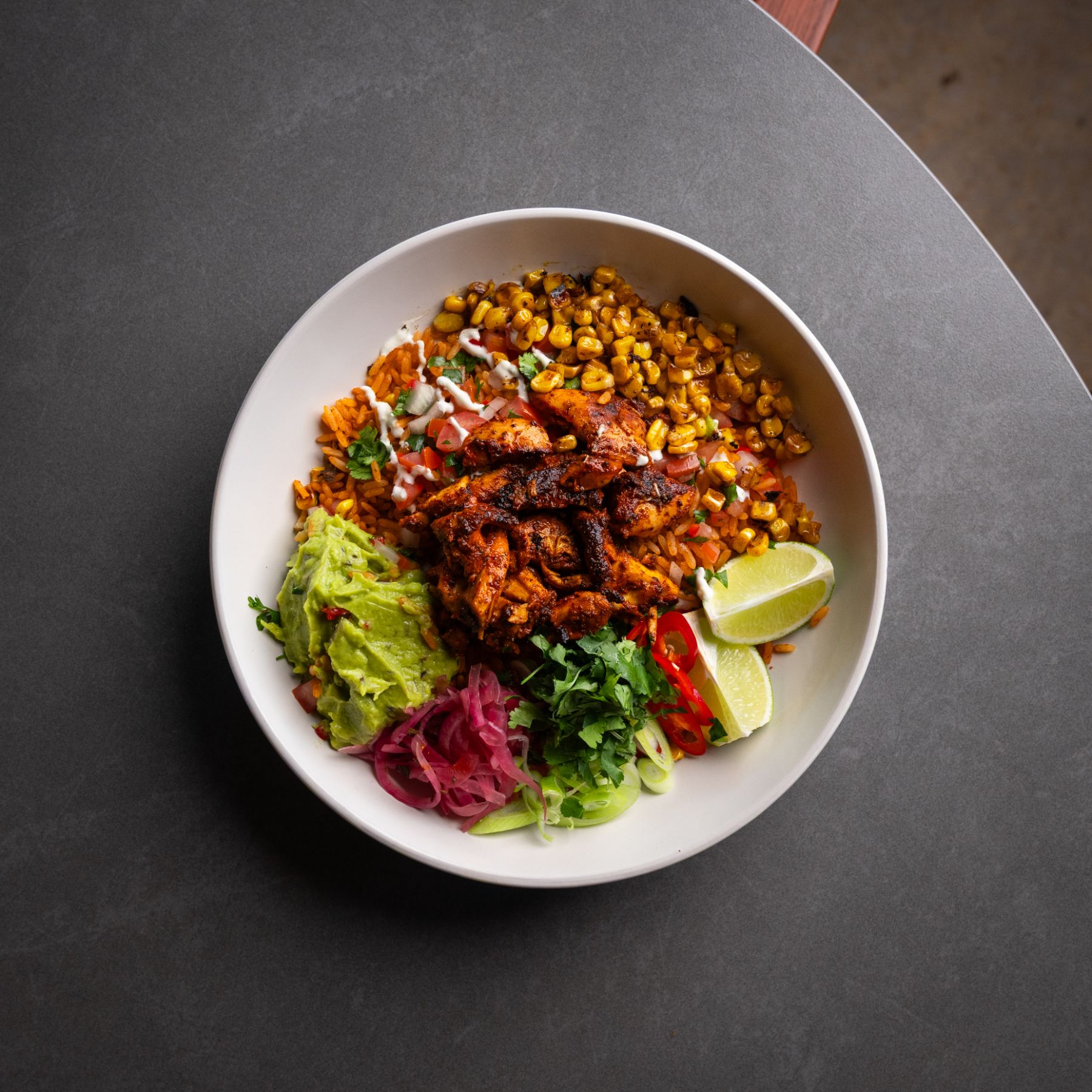 Chicken burrito bowl with charred corn and guacamole
